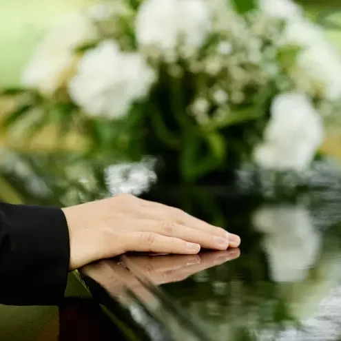 womans hand on casket